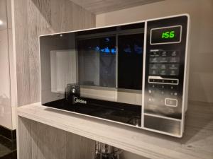 a microwave oven sitting on top of a shelf at Elegante AP em Sete Lagoas in Sete Lagoas +22 photos
