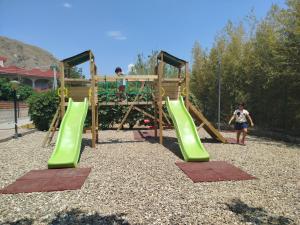 a playground with a slide and two people on it at Bouganville Residence in Calatabiano