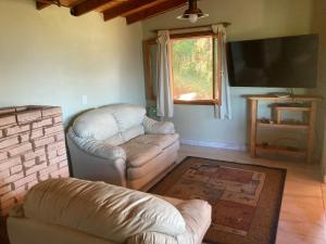 a living room with a couch and a flat screen tv at Las Morillas in El Bolsón