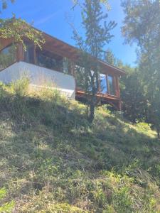 a house sitting on top of a grassy hill at Las Morillas in El Bolsón