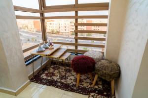a room with a table and two chairs in front of a window at L'horizon Aéroport Appartement in Marrakech