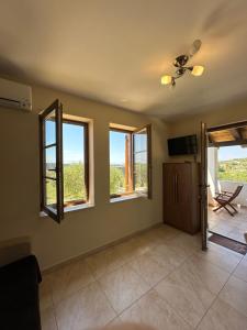 a living room with three windows and a television at Villa Karmen in Barbat na Rabu