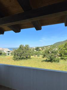 a window with a view of a field and trees at Villa Karmen in Barbat na Rabu