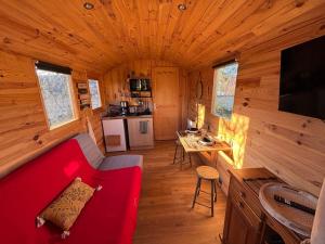 Una sala de estar con un sofá rojo en una cabaña. en La Roulotte Saintaise, en Saintes 10 fotos más