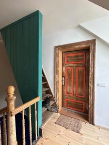 a staircase with a red door and a green wall at Design Studio in Hinterhof-Remise in Leipzig