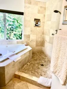 a bathroom with a tub and a sink and a window at Kona Garden Retreat in Kailua-Kona +22 photos