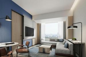 un soggiorno con un divano e una TV di Four Points by Sheraton Hengyang Zhengxiang ad Hengyang