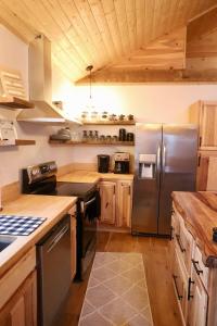 una cucina con frigorifero in acciaio inox e mobili in legno di Stonebrook Hollow Cabin a Tidwell