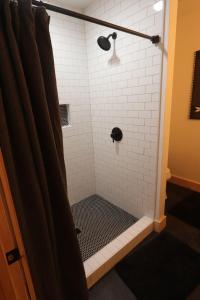 un bagno con doccia in bianco e nero di Stonebrook Hollow Cabin a Tidwell