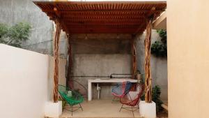 eine Terrasse mit 3 Stühlen und einem Tisch mit Markise in der Unterkunft Casa Eve Room 2 in Brisas de Zicatela
