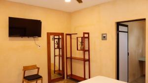 ein Zimmer mit drei Regalen und einem Flachbildfernseher in der Unterkunft Casa Eve Room 2 in Brisas de Zicatela + 15 Fotos