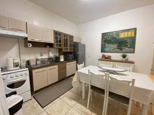 a kitchen with a white table and a white table and chairs at Casa em Governador Celso Ramos in Governador Celso Ramos
