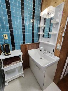 a bathroom with a white sink and a mirror at Fun stay大島 の1棟貸し宿 in Suo Oshima