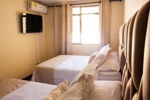 a hotel room with two beds and a window at Hotel Casa Manta Cali in Cali