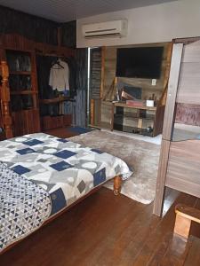 a bedroom with a bed and a flat screen tv at casarao24horas in Cuiabá