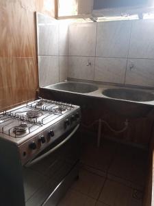 a kitchen with a stove and a sink in it at casarao24horas in Cuiabá