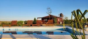 a house with benches next to a swimming pool at Cabañas Potrero de Marquez Paraiso Adult only in Potrero de Garay