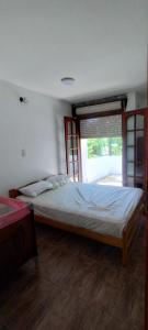 a large bed in a bedroom with a window at Casa in San Clemente del Tuyú
