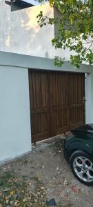 a garage with a wooden door next to a house at Casa in San Clemente del Tuyú