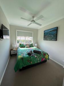 una camera da letto con un letto e un ventilatore a soffitto di Camellia Cottage Pet Friendly Farm Stay a Picton Altre 35 foto