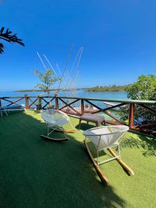 deux chaises et tables sur l'herbe près de l'eau dans l'établissement El Arca, à Tintipan Island