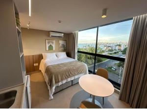 a bedroom with a bed and a large window at SH Flat in João Pessoa