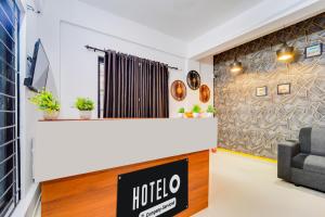 a hotel lobby with a hotel sign and a chair at Hotel O Cheranelloor Aster Medicity Formerly Abriz Residency in Cochin