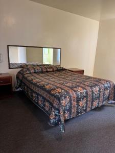 a bedroom with a bed with a large mirror at El Rancho Motel, Pasadena in Pasadena