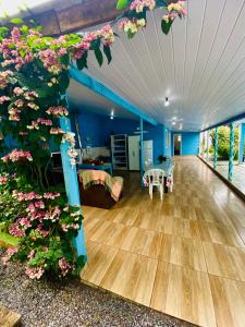 una sala de estar con suelo de madera y flores en Casa inteira em Pontal do Sul, en Pontal do Paraná