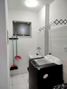a bathroom with a black and white toilet and a sink at AP 3 quartos à 10 min de Cabo Frio, Praia do Forte in São Pedro da Aldeia