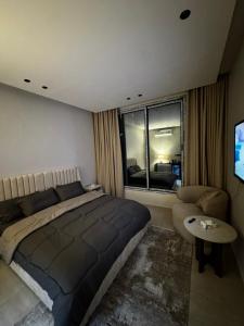a bedroom with a bed and a couch and a window at استديو ديار in Al Khobar +3 photos