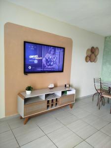 a living room with a flat screen tv on a wall at AP 3 quartos à 10 min de Cabo Frio, Praia do Forte in São Pedro da Aldeia