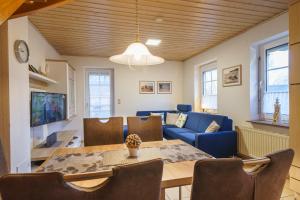a living room with a table and a blue couch at Achtern Diek 28A in Otterndorf