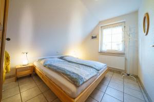 a bedroom with a bed and a window at Achtern Diek 28A in Otterndorf