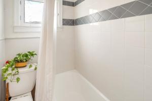 a bathroom with a tub and a toilet with a plant on it at 1 Mi to Old Town Historic Area Gem in Alexandria in Alexandria +16 photos