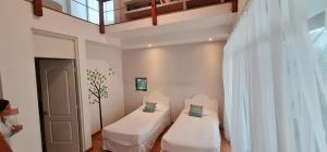 two beds in a room with a window at Casa La Ceiba in Cancún