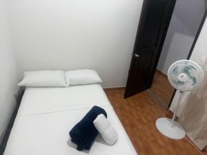 um pequeno quarto com uma cama e uma ventoinha em donde la abuela Josefa em Quimbaya