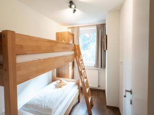 Pokój z 2 łóżkami piętrowymi i kotem na łóżku w obiekcie Alpensteinbock Saalbach D w Saalbach Hinterglemm