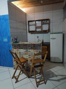 a kitchen with a table and a chair and a refrigerator at Quarto refrigerado,sala,cozinha completa,banheiro privativo in Cuiabá