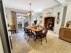 a dining room with a table and chairs and a fireplace at River Cottage in stunning location in Countisbury