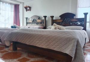 a bedroom with two beds and a window at Cabaña Rural BlueHousePaipa in Paipa