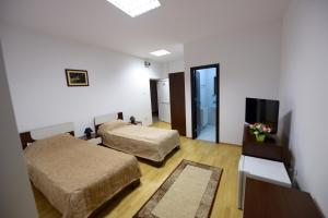 una camera d'albergo con due letti e una televisione di Hotel Sophia a Tecuci