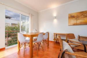 a dining room with a table and chairs and a window at Cabanas Beach Apartment in Cabanas de Tavira