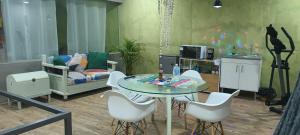 ein Wohnzimmer mit einem Glastisch und weißen Stühlen in der Unterkunft Departamento en renta in Yelateni