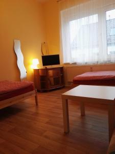 ein Wohnzimmer mit 2 Betten und einem TV in der Unterkunft Zu Hause Bei Freunden in Dortmund