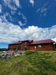 a large wooden house on top of a field at Timberline Cabin Near Bozeman in Bozeman