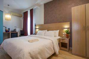 a hotel room with a large white bed and a desk at Rotonda Hotel in Thessaloniki +55 photos