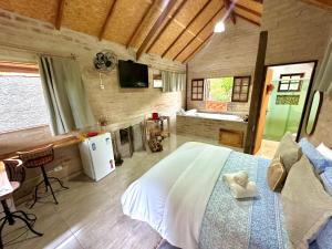 ein Schlafzimmer mit einem Bett und einem Fernseher in einem Zimmer in der Unterkunft Chalé na Montanha - Charme e Natureza in Santo Antônio do Pinhal