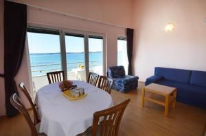 un soggiorno con tavolo e divano blu di Apartments Danijela 2 a Sukošan (San Cassiano)