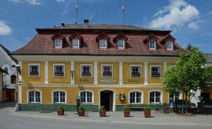 a large yellow building with a red roof at Hoftaverne Ziegelböck in Vorchdorf